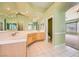 Bathroom featuring dual sinks, mirrors, tile flooring, and plenty of natural light at 9733 Camden Hills Ave, Las Vegas, NV 89145