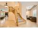 Elegant foyer showcasing a curved staircase, hardwood floors, and views of the living room and dining area at 9733 Camden Hills Ave, Las Vegas, NV 89145