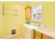 Bright laundry room features a washer, dryer, utility sink, storage cabinet, wire shelves, and a window at 9733 Camden Hills Ave, Las Vegas, NV 89145