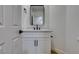 A modern white bathroom vanity features a black faucet and a sleek square mirror at 9855 Ashton Pines Ct, Las Vegas, NV 89147