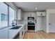 The updated eat-in kitchen features stainless steel appliances, light countertops, and wood-look flooring at 9855 Ashton Pines Ct, Las Vegas, NV 89147