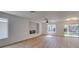 Bright open-concept living room featuring wood flooring, a cozy fireplace, and natural light from the large windows at 9855 Ashton Pines Ct, Las Vegas, NV 89147
