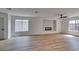 Open living room with wood floors, a modern fireplace, and large windows providing ample natural light at 9855 Ashton Pines Ct, Las Vegas, NV 89147