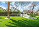 Lush backyard with a large lawn, palm trees, and modern outdoor seating areas for relaxation at 1108 Pine Island Ct, Las Vegas, NV 89134