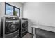 Well-lit laundry room equipped with modern, front-load washer and dryer set at 1108 Pine Island Ct, Las Vegas, NV 89134