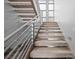 Contemporary carpeted staircase featuring a sleek metal railing and modern design elements at 1108 Pine Island Ct, Las Vegas, NV 89134