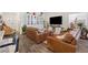 Spacious living area featuring wood-style floors and comfortable brown leather seating at 1174 King Lark St, Henderson, NV 89011