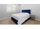Bedroom featuring a queen bed with blue headboard, bedside table, and a large window at 12169 Castilla Rain Ave, Las Vegas, NV 89138
