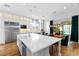 Modern kitchen with stainless steel appliances, a large island, and an adjacent dining space filled with natural light at 12169 Castilla Rain Ave, Las Vegas, NV 89138