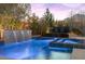 Beautiful pool and spa with stacked stone waterfall feature and lush landscaping at 12169 Castilla Rain Ave, Las Vegas, NV 89138