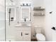 A bright bathroom featuring a glass-enclosed shower, vanity with a bowl sink, and floating shelves for storage and decor at 1408 E Carson Ave, Las Vegas, NV 89101
