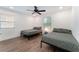 A spacious bedroom with two beds, sleek ceiling fan and windows, offering a comfortable and well-lit living space at 1408 E Carson Ave, Las Vegas, NV 89101