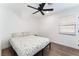 Simple bedroom with wood-look floors, a ceiling fan, and a window bringing in natural light at 1408 E Carson Ave, Las Vegas, NV 89101