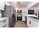 Modern kitchen with stainless steel appliances, white cabinets, marble countertops, and stylish black hardware at 1408 E Carson Ave, Las Vegas, NV 89101