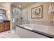 Bathroom featuring a glass enclosed shower and a large soaking tub at 145 E Harmon Ave # 201, Las Vegas, NV 89109
