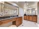 Bathroom showcasing double vanities with black countertops and well-lit mirrors at 145 E Harmon Ave # 201, Las Vegas, NV 89109