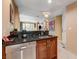 This open-concept kitchen features a stainless steel dishwasher, dark countertops and sleek wood cabinetry at 145 E Harmon Ave # 201, Las Vegas, NV 89109
