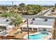 Aerial view showcases kidney pool, covered patio, gravel landscaping, and mature trees in a fenced backyard at 2021 N Michael Way, Las Vegas, NV 89108