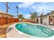 A refreshing kidney-shaped pool and patio, surrounded by desert landscaping and an arched patio at 2021 N Michael Way, Las Vegas, NV 89108