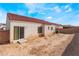 Large backyard featuring dirt landscaping, a brick wall, and a sliding glass door providing access to indoor and outdoor spaces at 2117 Mountain Sunset Ave, North Las Vegas, NV 89031