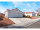 Side angle shot of a single story home, showing two car garage, and xeriscaped yard at 2117 Mountain Sunset Ave, North Las Vegas, NV 89031