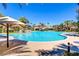 Large community pool with palm trees, lounge chairs, and a building in the background at 236 Dog Leg Dr, Las Vegas, NV 89148