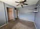 Bedroom with brown carpet, ceiling fan, closet, and shelving unit ready for personalization at 2501 Capistrano Ave, Las Vegas, NV 89121
