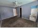 Carpeted bedroom with a ceiling fan and natural light, plus an en-suite bathroom at 2501 Capistrano Ave, Las Vegas, NV 89121
