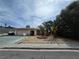 Charming single-story home featuring a desert landscape, mature palm trees, and a covered entryway at 2501 Capistrano Ave, Las Vegas, NV 89121