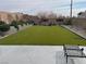 This backyard features lush green artificial turf, statues, block wall, and seating area at 2674 Duneville St, Las Vegas, NV 89146