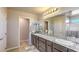 This bright bathroom features a double sink vanity, granite countertop, and decorative mirrors at 2674 Duneville St, Las Vegas, NV 89146
