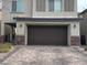 Attached two-car garage with brick driveway and well-maintained landscaping for curb appeal at 2674 Duneville St, Las Vegas, NV 89146