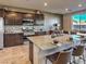 Modern kitchen with granite countertops, stainless steel appliances, and spacious island with seating at 2674 Duneville St, Las Vegas, NV 89146