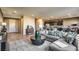 Open-concept living room boasts modern decor, including a large sectional sofa and adjacent gourmet kitchen at 2674 Duneville St, Las Vegas, NV 89146
