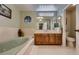 Bathroom featuring a tub, decorative vases and octagon window, with dual mirrors at 2721 Family Ct, Las Vegas, NV 89117