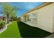 Green backyard with artificial turf surrounded by a privacy fence and mature landscaping at 3658 Auckland Castle St, Las Vegas, NV 89135