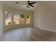 Bright, open bedroom featuring wood floors, a ceiling fan, and abundant natural light from multiple windows at 3658 Auckland Castle St, Las Vegas, NV 89135
