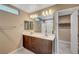 Well-lit bathroom featuring dual sinks, modern lighting, and access to the walk-in closet at 3736 Paseo De Paz Ave, Las Vegas, NV 89115