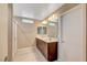 Modern bathroom with dual sink vanity, tile flooring, and a glass-enclosed shower at 3736 Paseo De Paz Ave, Las Vegas, NV 89115