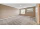 Large bedroom with two windows, soft carpet, neutral colors, and a door at 3736 Paseo De Paz Ave, Las Vegas, NV 89115