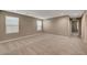 A large, empty room with neutral colors, large windows, and soft carpeting throughout at 3736 Paseo De Paz Ave, Las Vegas, NV 89115