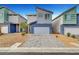 Modern two-story home featuring a gray two-car garage and a paved driveway at 3736 Paseo De Paz Ave, Las Vegas, NV 89115