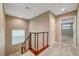 Hallway with a view to a room with large windows, staircase with wood railing and neutral paint at 3736 Paseo De Paz Ave, Las Vegas, NV 89115