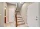 This hallway features modern white tile floors and a carpeted staircase with wood railing at 3736 Paseo De Paz Ave, Las Vegas, NV 89115
