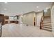Open-concept living space with modern kitchen, tiled flooring, and staircase at 3736 Paseo De Paz Ave, Las Vegas, NV 89115