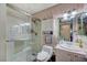 Cozy bathroom with glass shower, floral wallpaper, and vanity with stylish mirror at 405 Longtree Ave, Henderson, NV 89011