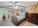Bedroom features a comfortable bed, ceiling fan, side tables, and a glimpse into the adjoining room, which includes a kitchen at 405 Longtree Ave, Henderson, NV 89011