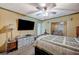 Bedroom featuring a bed, a ceiling fan, dresser, and a door leading to a room with upholstered chairs at 405 Longtree Ave, Henderson, NV 89011
