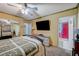 Bedroom with bed, ceiling fan, dresser, door to bathroom and a view to a room with upholstered chairs at 405 Longtree Ave, Henderson, NV 89011