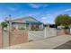 Charming single-story home featuring a gated front yard, covered entry, and mature trees under a bright blue sky at 405 Longtree Ave, Henderson, NV 89011